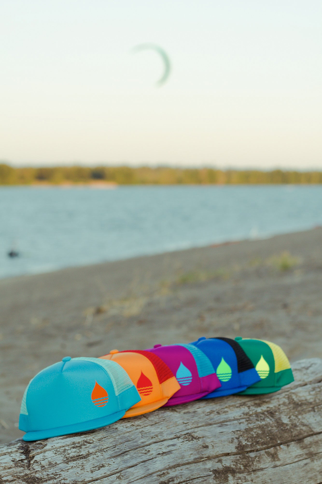 BUOY WEAR's new floating hat collection on the beach with a kite in the background