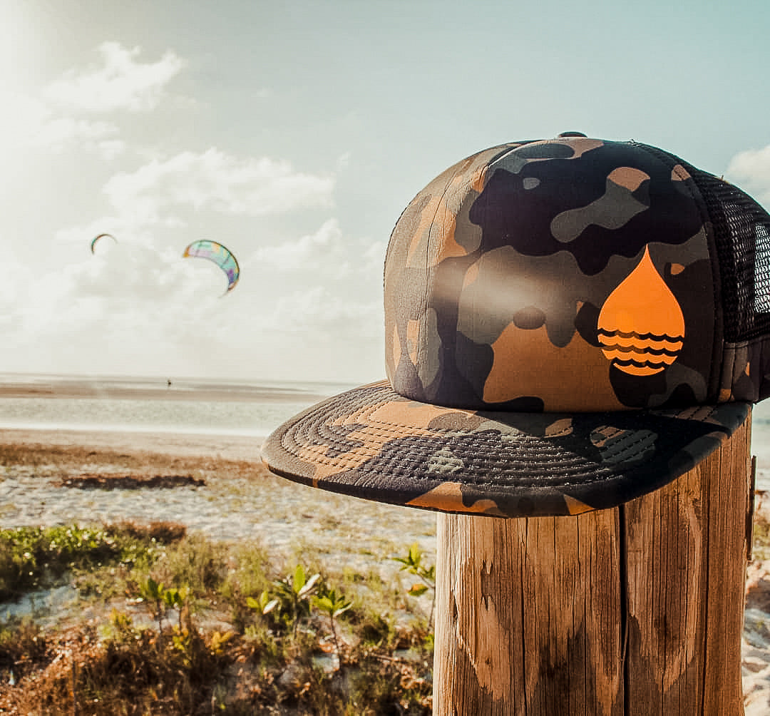 BUOY WEAR's floating hat and kiteboarders in the background