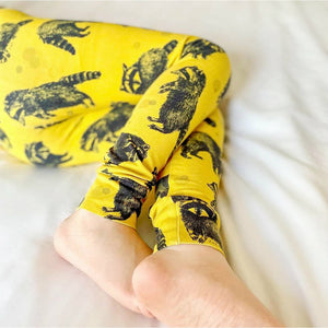 Raccoon print child and baby leggings on a mustard yellow background
