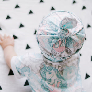 baby girl wearing an organic candy unicorns long leg popper romp with matching jersey baby hat by bayridgecaskandkeg
