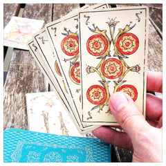 Curio & Co. looks at low-cost alternatives to a big night out with friends: Game night at home. Image of tarot card game being played, using Musterberg deck of tarot cards, www.curiosnaco.com