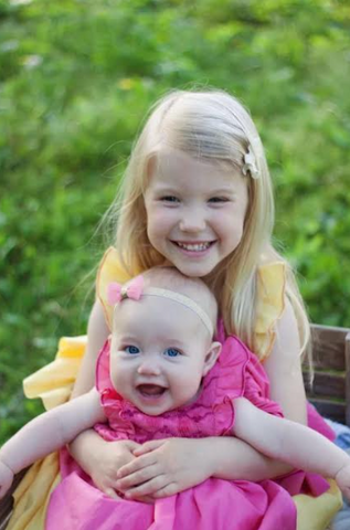 Savannah: a real ray of sunshine in her Yellow Netti Dress and her baby sister Caroline looking like a blooming rose in her fuschia pink Netti dress 