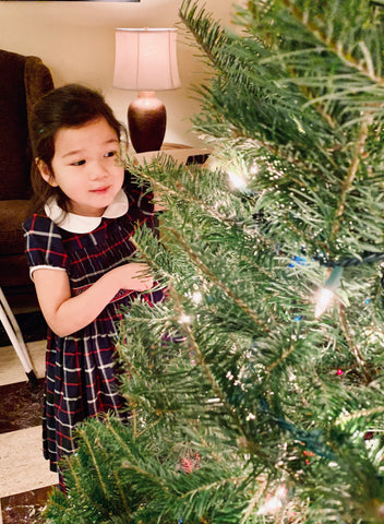 The most adorable little Santa helper decorating the Christmas tree in her special handmade Tartan smocked dress with delicate silver threads.   Thank you to Kate for wearing our dresses with such elegance!