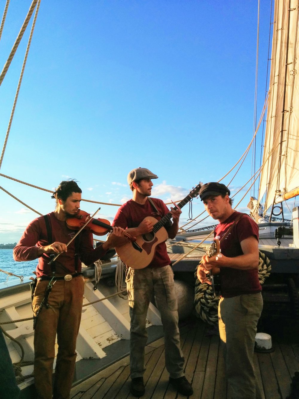 three man band playing on a boat