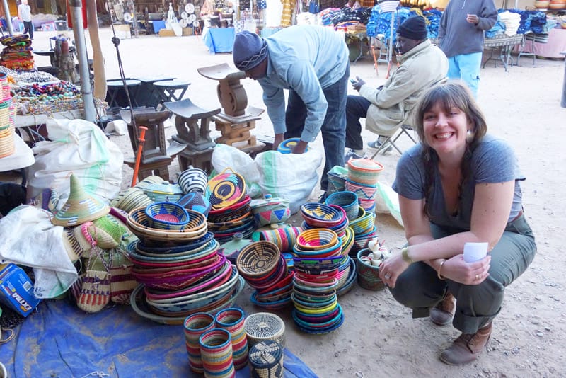 Designer Betsy Cross posing with colorful woven baskets