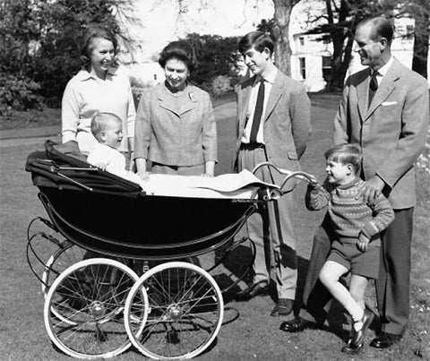 Queen Elizabeth of England and family surrounding young Prince sitting in Silver Cross pram