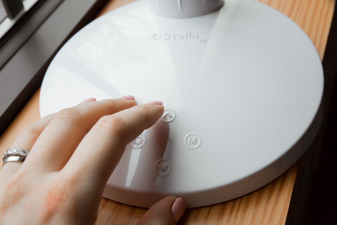 Woman pressing simple raised buttons to turn on light.