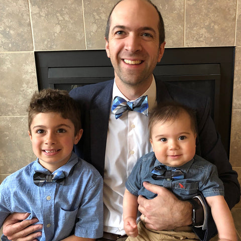 Family wearing blue, silver, and black plaid bow ties for Christmas