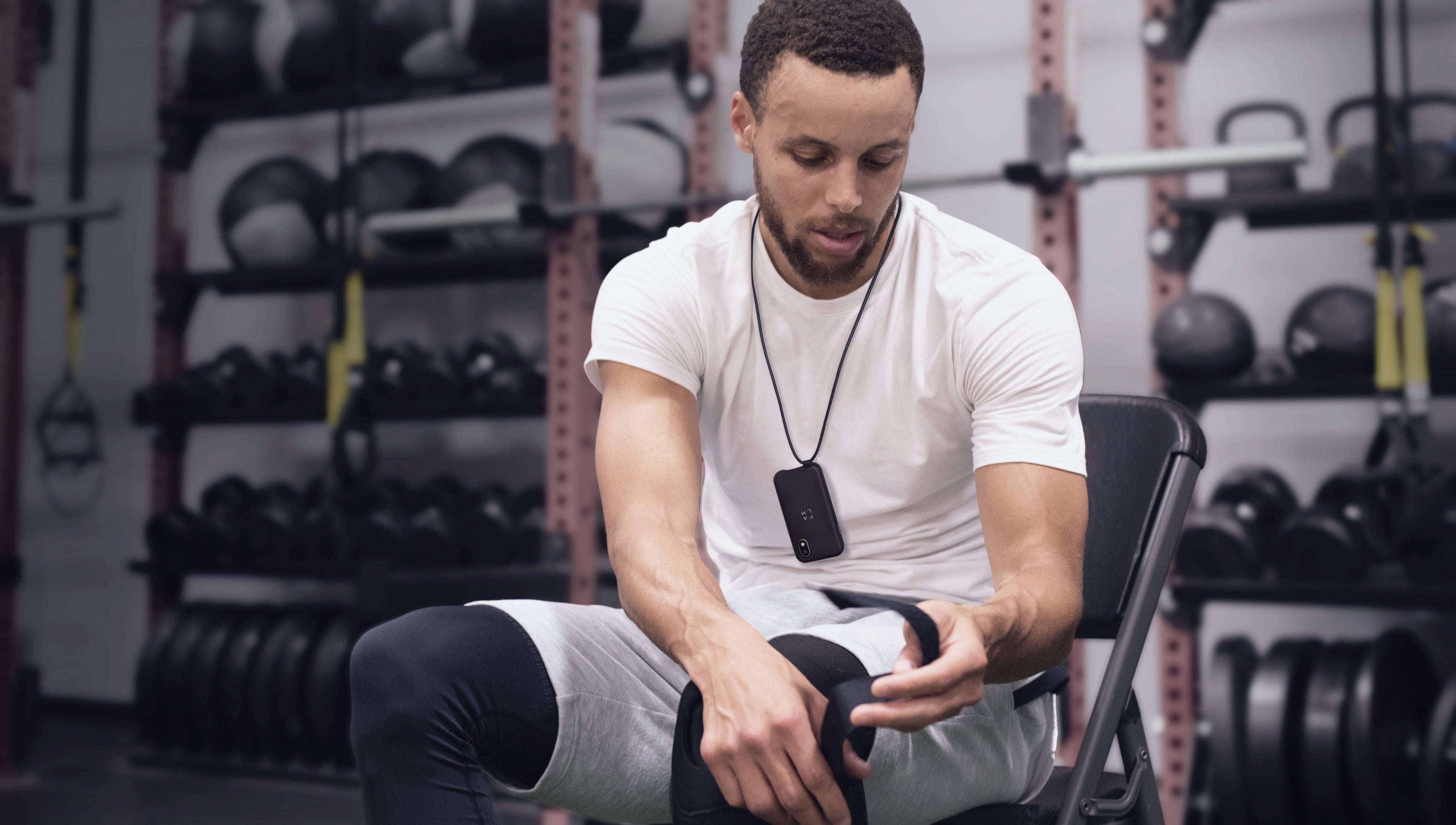 Stephen Curry wears a Palm smartphone in a lanyard case