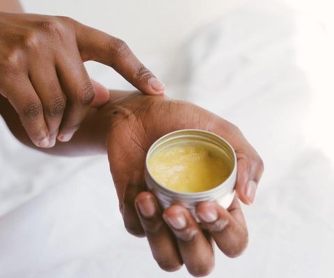 Woman applying CBD cream to hand for arthritis