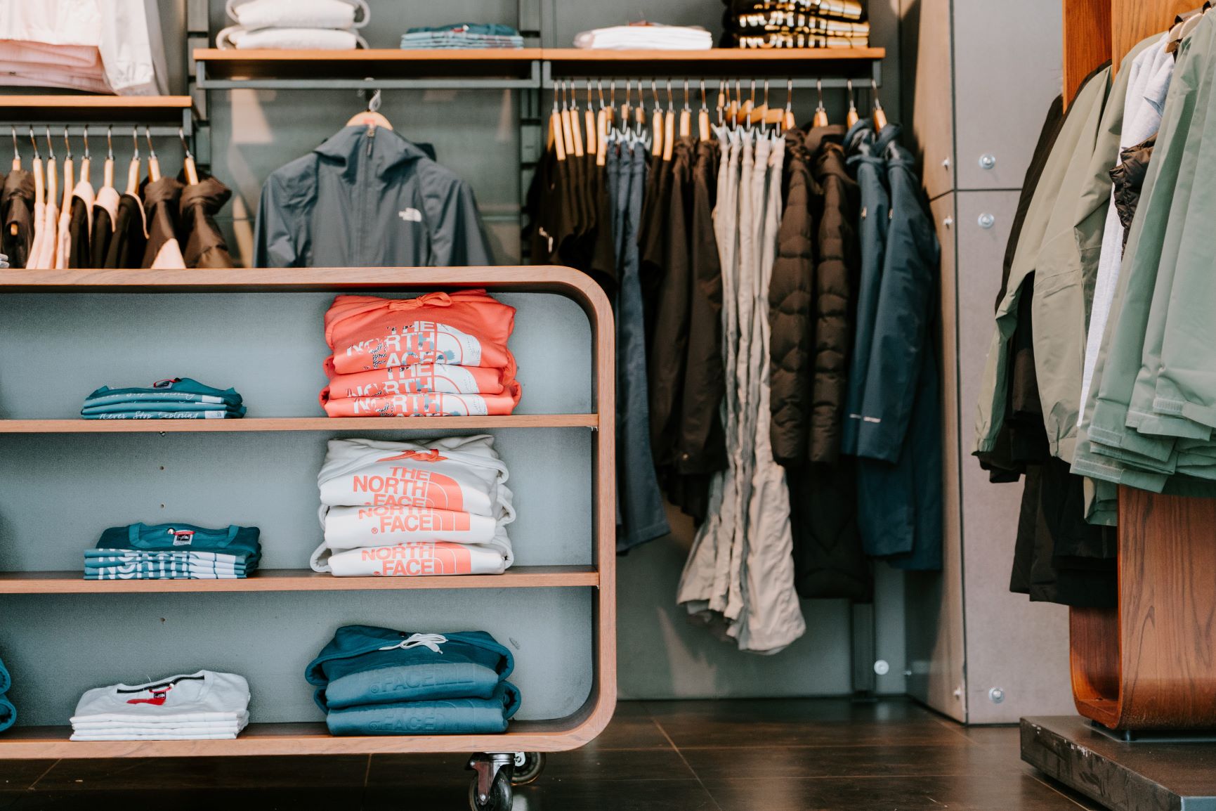 An example of well-organized, walk-in men’s closet where pants, shirts, and jackets are hung on wood hangers