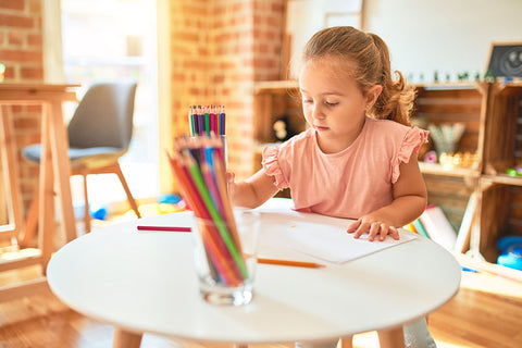 Girl drawing on Montessori activity table