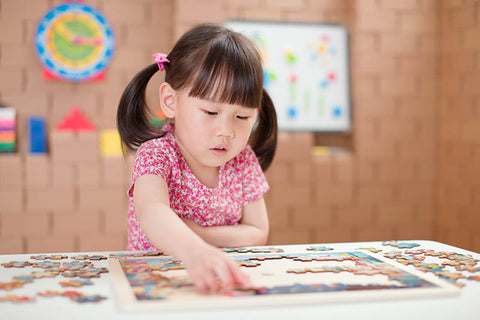 Girl playing with Montessori puzzle
