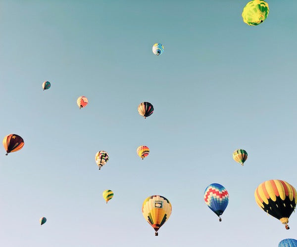 colorful hot air balloons floating in a blue sky