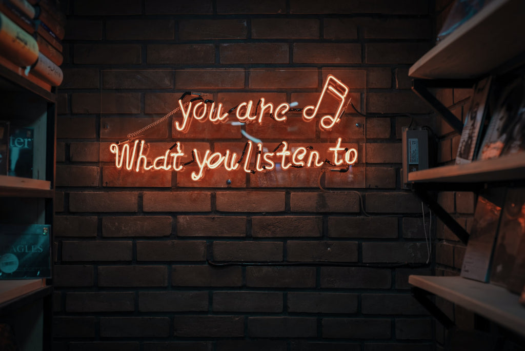 Neon sign saying you are what you listen to. Unsplash.