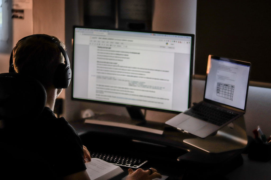 Man sitting at keyboard wearing headphones.