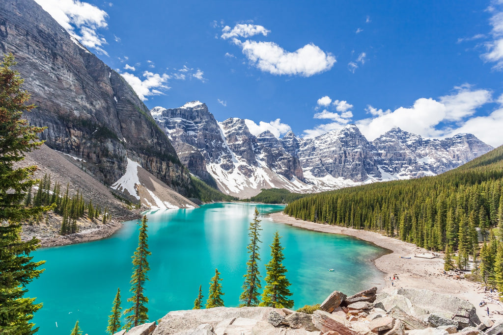 a lake surrounded by snow covered mountains and trees