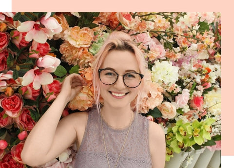 woman standing in front of flower wall