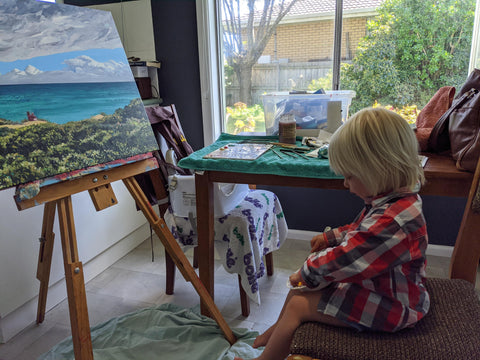 Toddler eating mango at my easel art life artist kitchen family painting acrylic painting beach australia landscape seascape