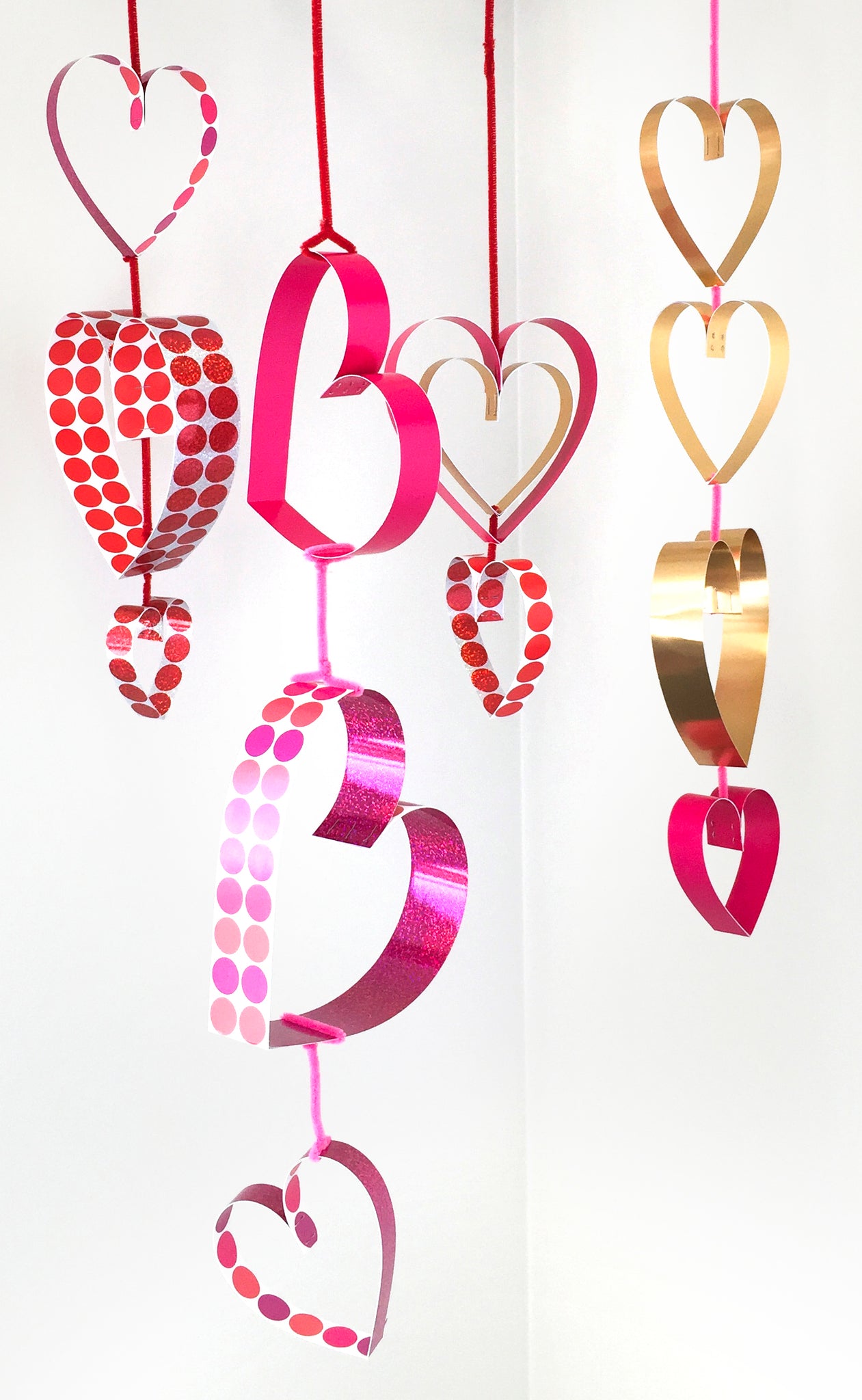 Easy DIY paper Valentine's Day hearts dangling decorations hang from ceiling