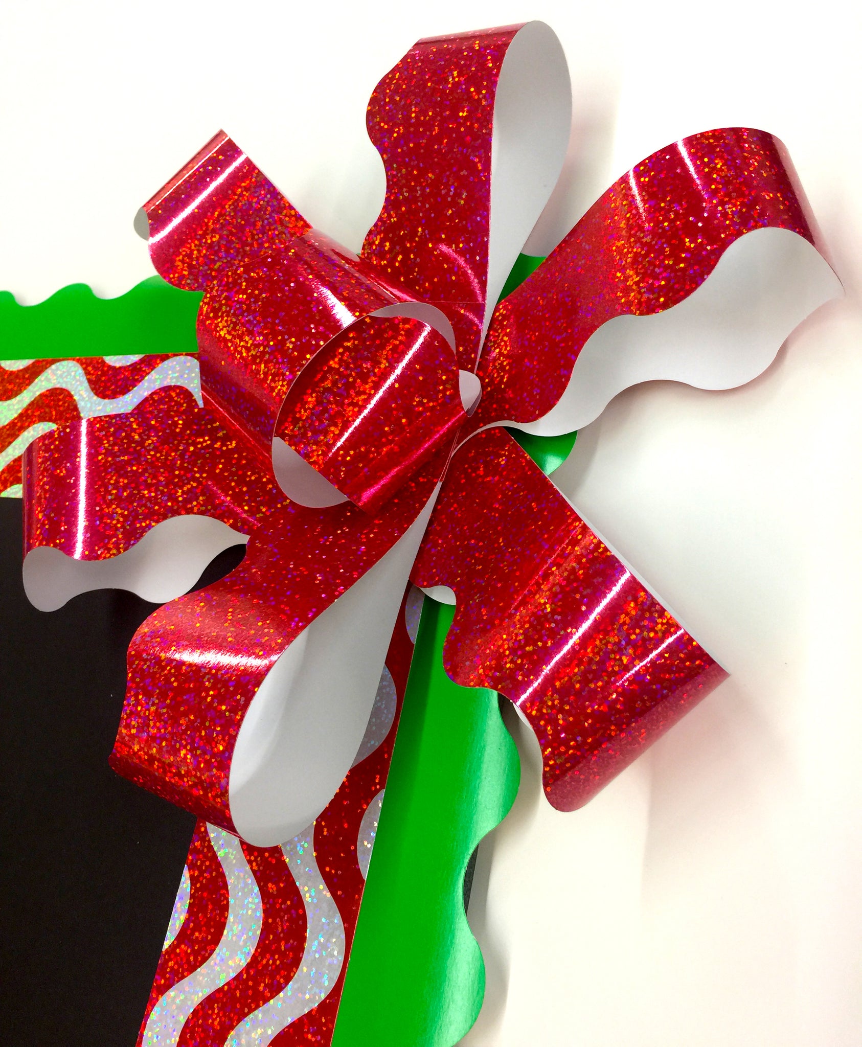 Big red sparkle paper bow for Christmas bulletin board. DIY how to make a paper bow.