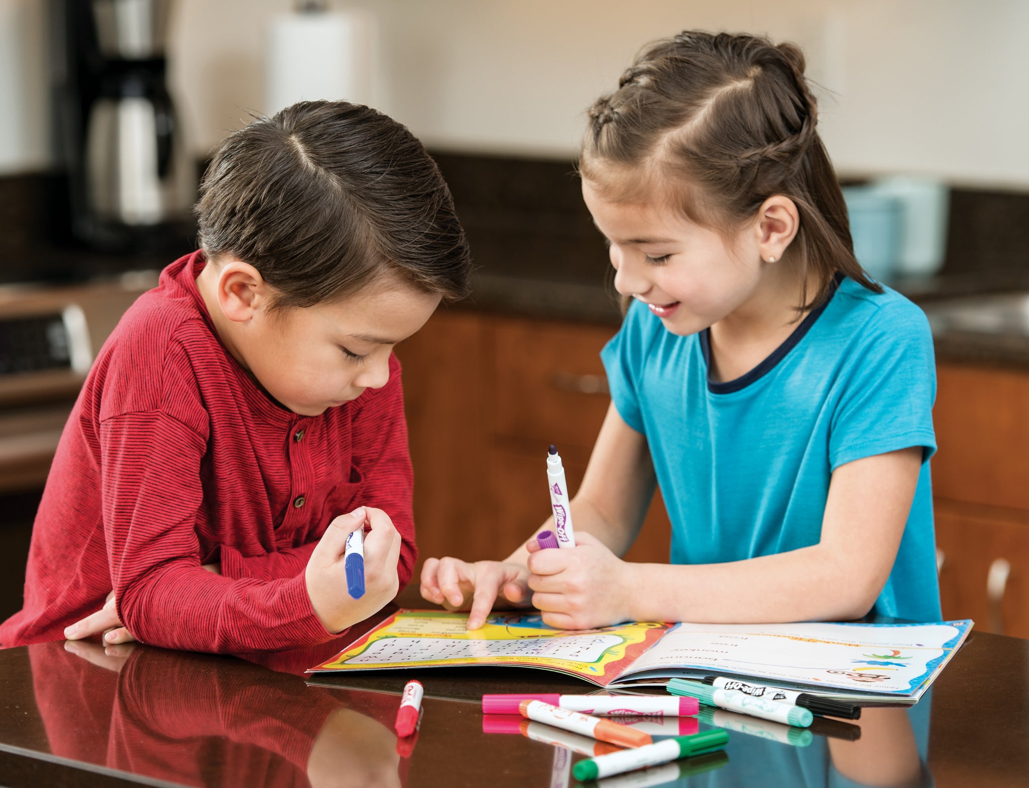 Kids doing a math workbook in the kitchen