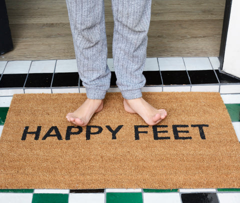 feet on coir doormat that states "happy feet"