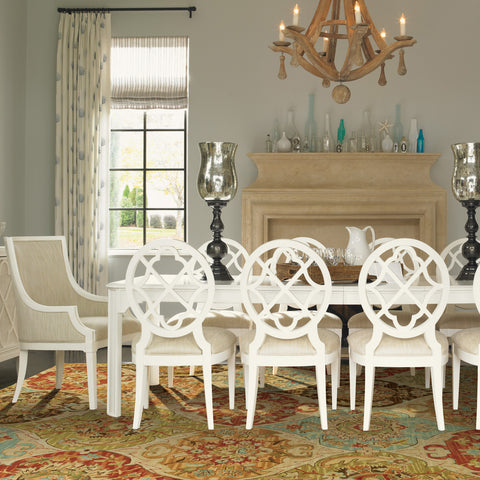 dining room with white chairs and rug underneath