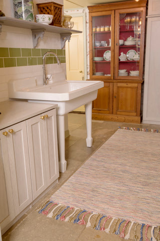 handwoven rug infront of sink in a country kitchen.