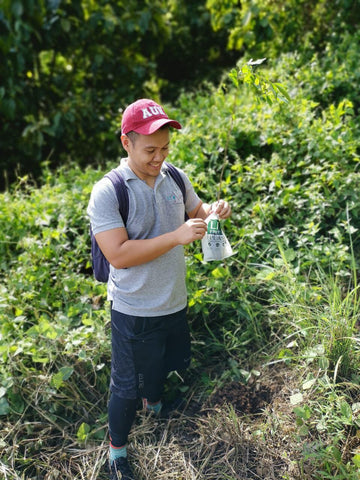 Josh from EcoNest Philippines with his native Narra tree held inside a cassava biobag