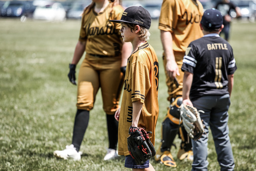 Warstic Woodmen bat boy watching the game