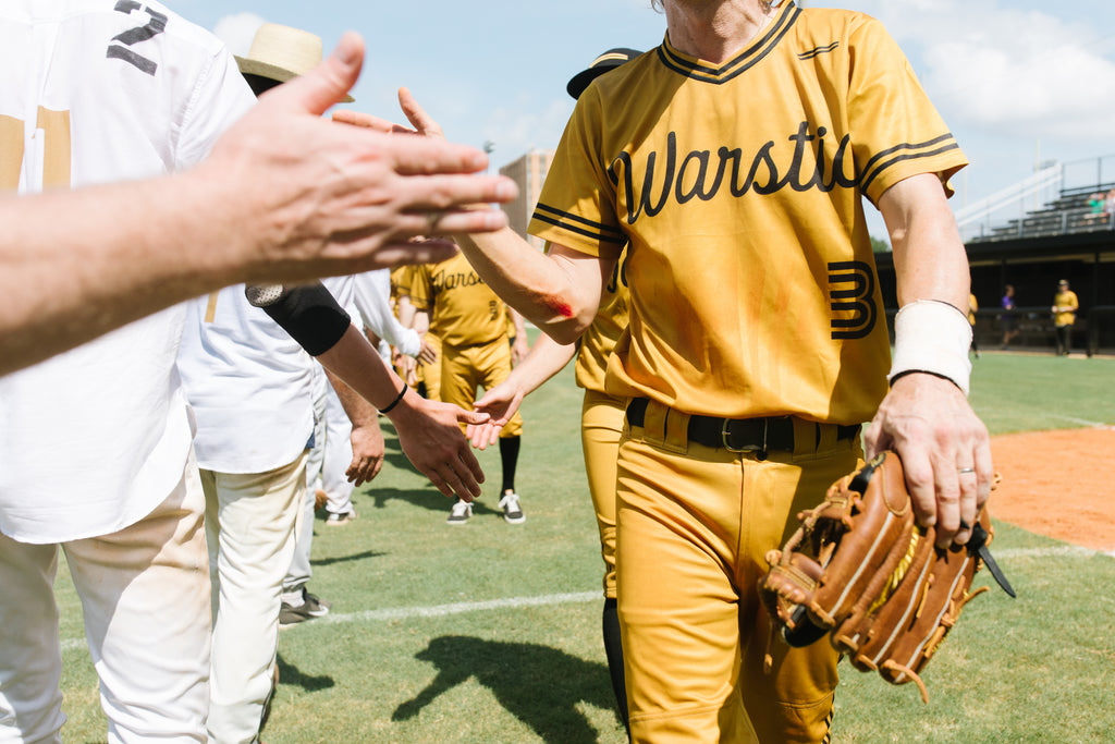 The victorious Warstic Woodmen meet the defeated Alabama Slammers at the end of the game to slap hands.