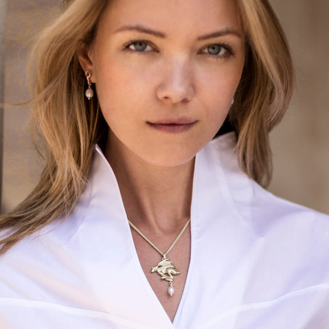 Blonde young woman wearing solid silver carved hare with a cultured pearl drop necklace