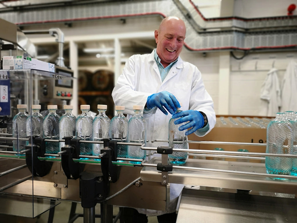 John happily getting hands-on with the bottling line.