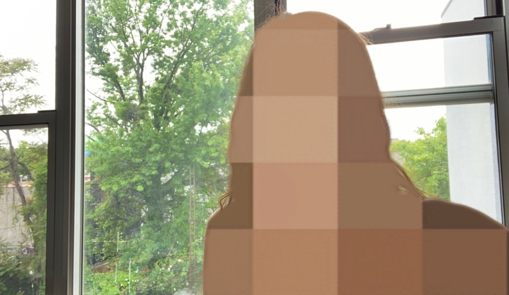 A photo taken with the Body Blur Instagram filter. The image is a selfie in front of a window, but the person is blurred with pixelated squares.