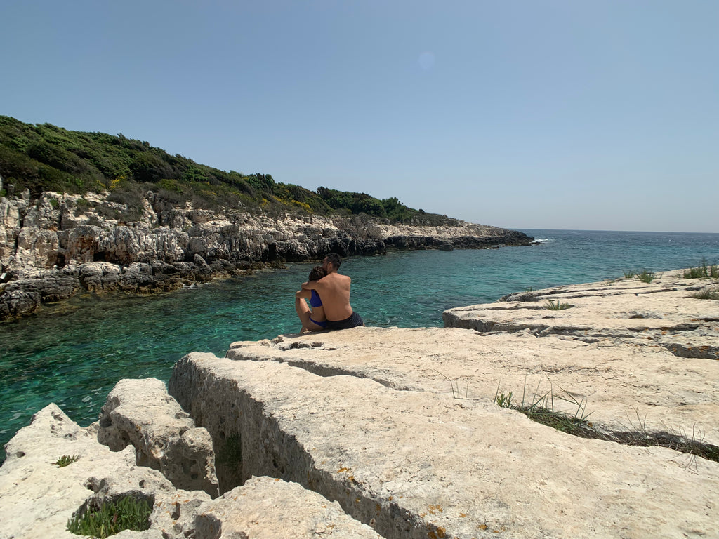 Couple sitting by water at Cape Kamenjak, Croatia