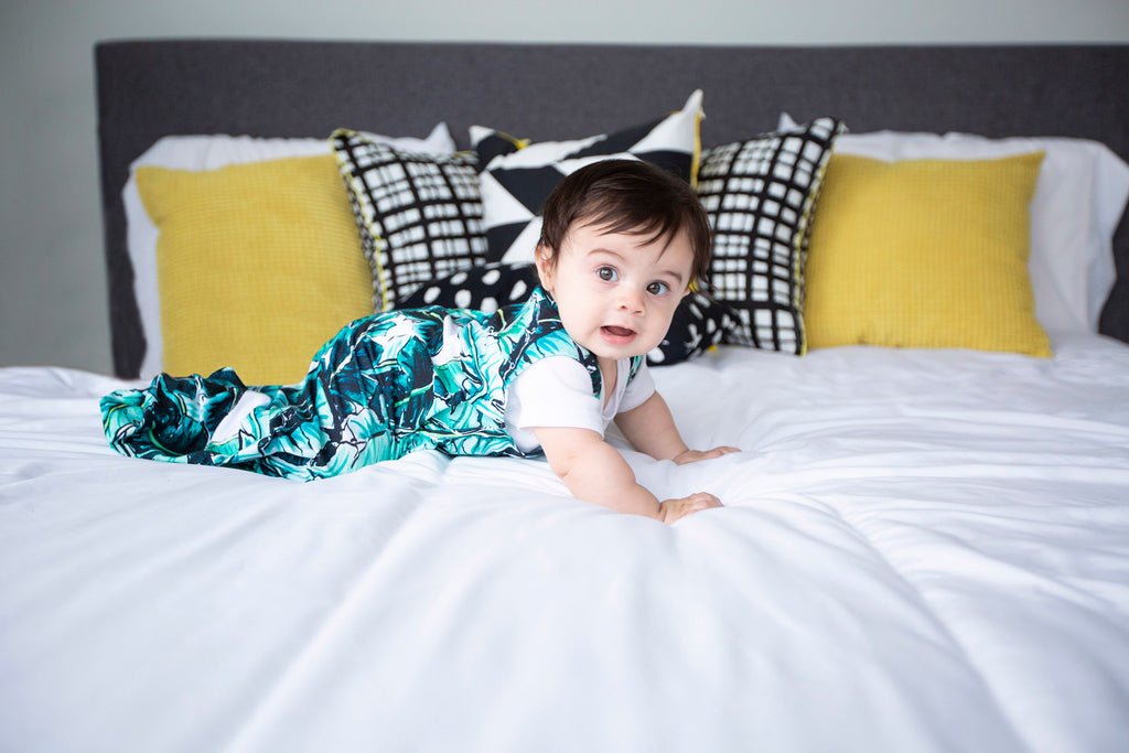 baby in Kauai One sleep sack crawling across bed