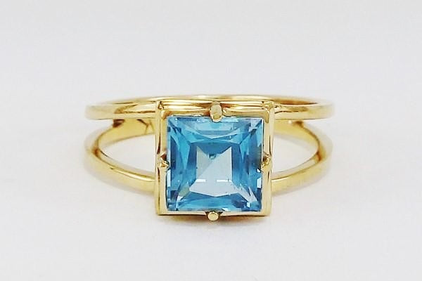 bague or montrant grande topaze bleue