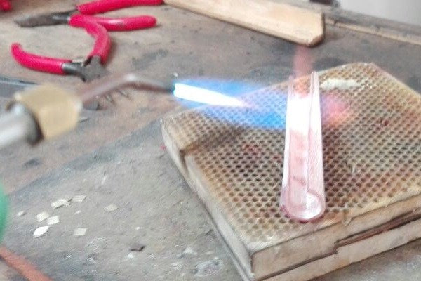 chauffe au chalumeau de bijoutier du tube d'argent en cours de fabrication