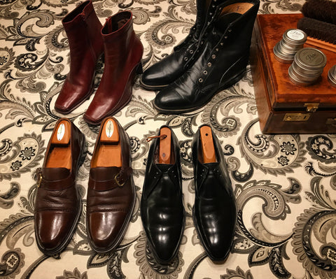 Flat lay of a shoe shine table - women’s and men’s boots, dress shoes, and loafers.