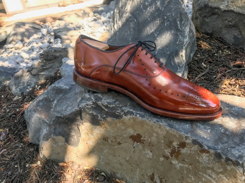 Single Allen Edmonds Weybridge in Walnut profile on rocks shined with All Natural Walnut Cream Polish