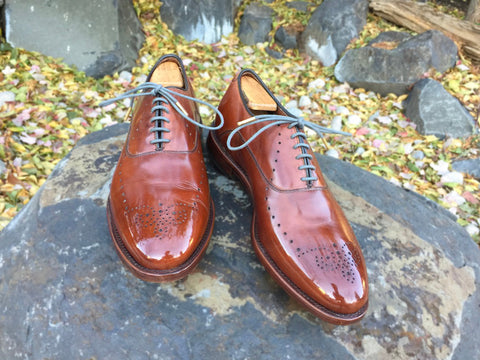 Lensing a Mirror Shined Pair of Allen Edmonds Weybridge on rocks with fall leaves in the background