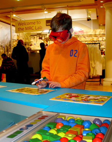 Young boy trying a game task with low vision to simulate impairment