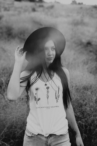 Graphic Style Tank top with Pacific Northwest Wildflowers on the front. Cute Wide Brim Hat. Field. Summer time. Golden Hour. Wearing white tank tops with jeans and jeans shorts. Summer time. Wenatchee, Washington. PNW Style. Pacific Northwest. Mountains. Mountain Style.