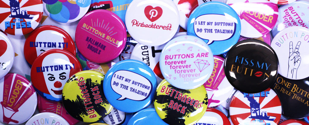 Pile of colorful pinback buttons, receive free gift with purchase