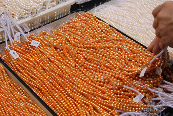 strings of orange dyed pearls
