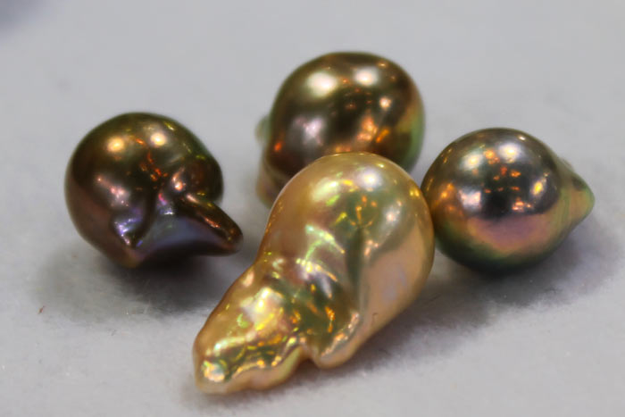 four golden pearls in different hues