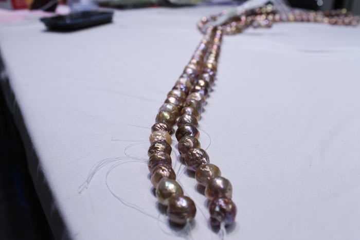 a pair of dark colored pearl strands