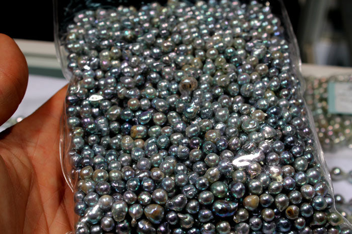 a bag of different colored Akoya pearls