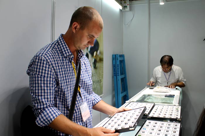 scrutinizing a tray of Tahitian pearls